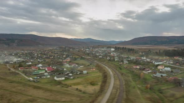 Aerial Timelapse of a Village in the Autumn Carpathian Mountains Covered with Spruce Forests Under a