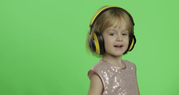 Girl in Glossy Dress and Headphone Listening To Music and Dancing. Chroma Key