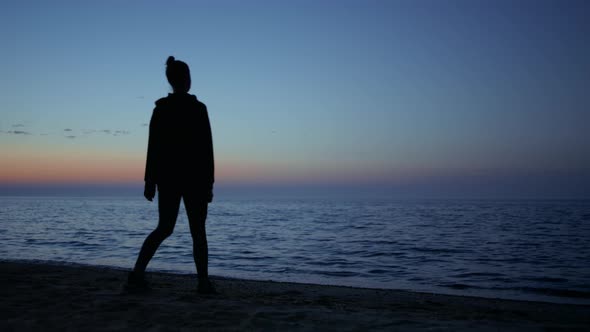 Unknown Yogi Woman Practicing Relaxing Exercises on Seashore Beautiful Evening