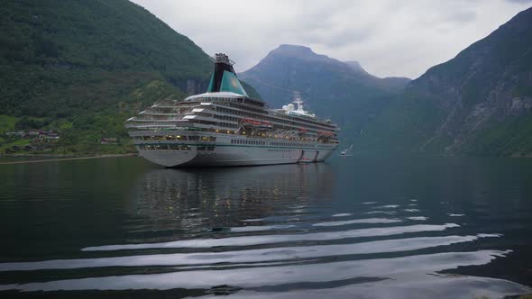 Large Luxury Cruise Ship Is Moored in Geiranger Fjord at Summer Day. Green Mountains. Norway