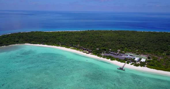 Beautiful aerial tourism shot of a sunshine white sandy paradise beach and aqua turquoise water back