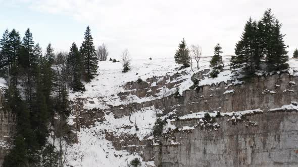 Flying up to snow covered mountain top, revealing a small remote cabin