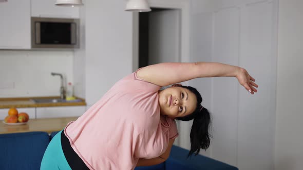 Smiling Woman in Sportswear Exercising to Lose Weight Doing Side Bends