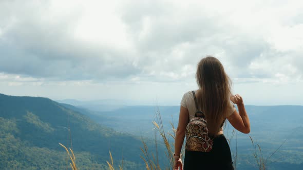 Inspired Travel Woman Raising Her Arms Up Standing on Top of Mountain