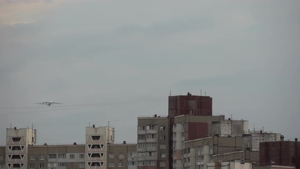 Low Angle Rotating Camera with a Airplane Flying Over the Top Big City Buildings