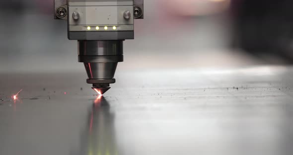 Laser Cutting Process On A Sheet Of Stainless Steel In A Factory. - close up shot