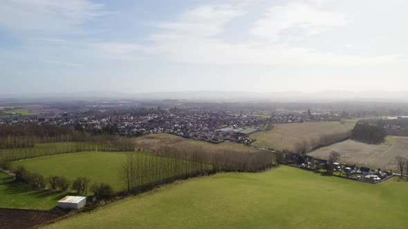 A rising aerial drone view looking over the fields beside Blairgowrie and Rattray in Perthshire, Sco