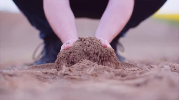 Farmer Examining Organic Soil in Hands, Farmer Touching Dirt in Agriculture Field