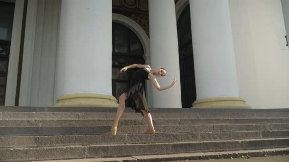 Camera Approaches To Slim Confident Elegant Ballerina Dancing on Urban Stairs