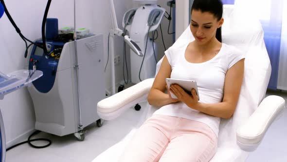 Female patient using digital tablet in clinic