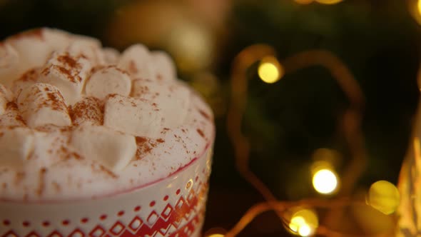 Closeup dolly shot of Christmas mug with hot chocolate, marshmallow and cinnamon