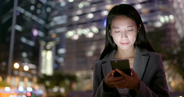 Woman use of mobile phone for online at outdoor at night