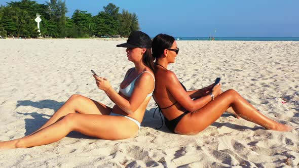 Ladies together happy together on paradise lagoon beach holiday by blue ocean with white sandy backg