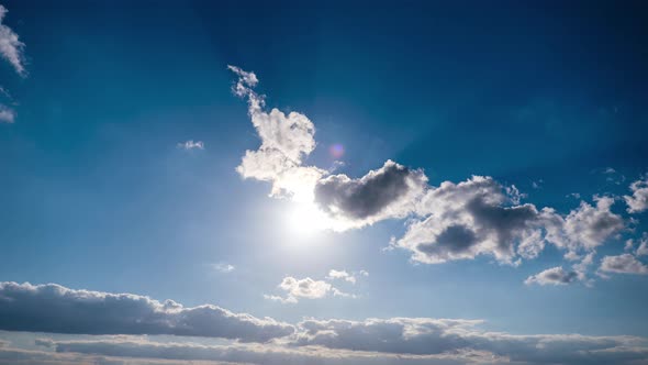 ÇTimelapse of Gray Cumulus Clouds Moves in Blue Sky. Sun Rays Shine. Cloudspace