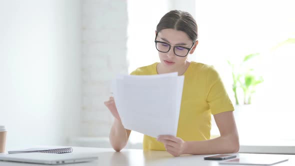 Woman Celebrating Success while Reading Documents