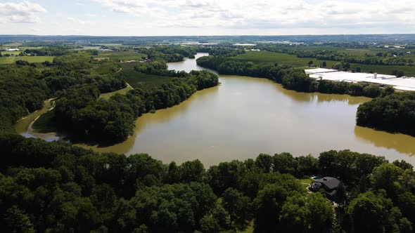 Aerial view of a beautiful pond surrounded by nature and luxury private homes. Aerial view of calm w