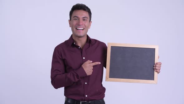 Young Happy Hispanic Businessman Holding Blackboard and Giving Thumbs Up