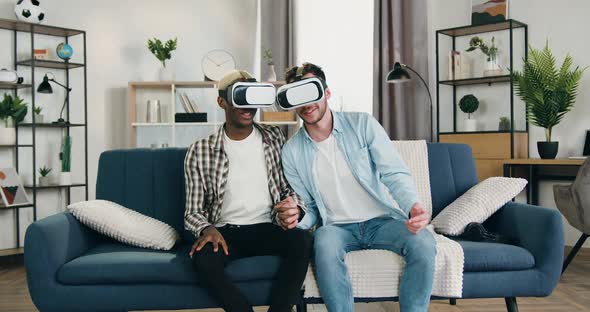 Young Gay Couple Holding by their Hands Enjoying Virtual Vision in Special 3d glasses