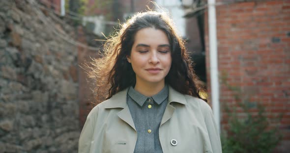 Slow Motion Portrait of Pretty Girl Smiling Looking at Camera Standing Outdoors