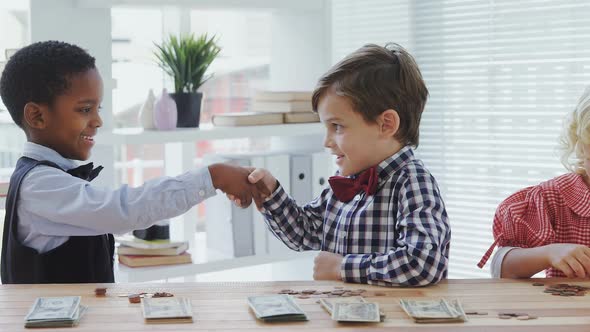 Kids as business executives shaking hands 4k