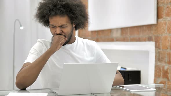 Yawning Tired African Man Working on Laptop