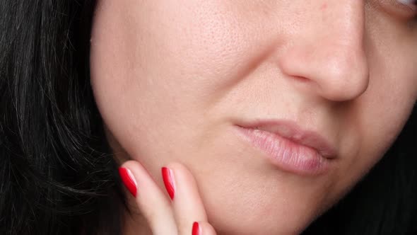 Female Face Close-up. Skin Texture with Enlarged Pores. The Girl Touches the Fingers of the Problem