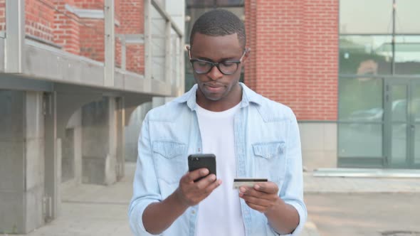 African Man Having Online Payment Failure on Smartphone in Street