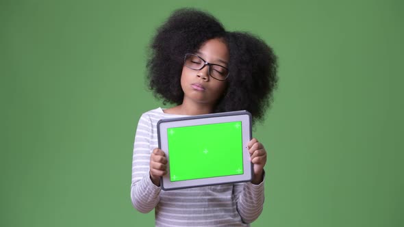 Young Cute African Girl with Afro Hair Thinking While Showing Digital Tablet To Camera