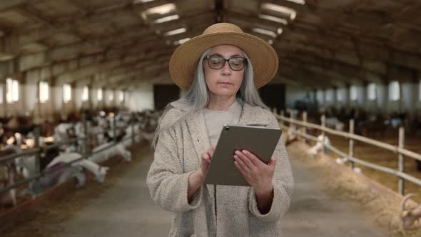 Female Agronomist Using Digital Tablet at Goat Farm