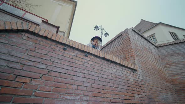 Female tourist on the top of stairway following the camera and showing her tangue.