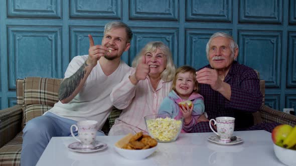 Multigenerational Family Watch TV with Young Girl Kid at Home Laughing While Watching Cartoon Movie