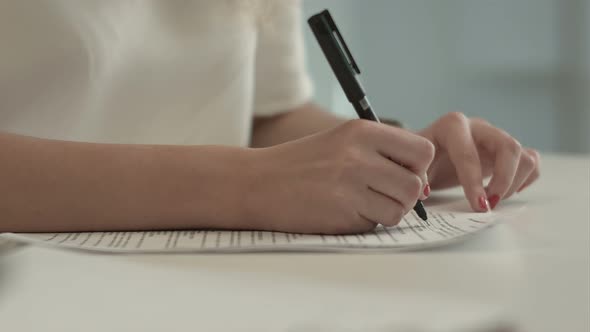 Businesswoman Writes on a Document at Her Office