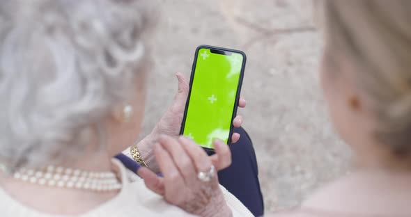 Green Screen Smartphone Device Display Used By Woman and Senior Grandmother at Park