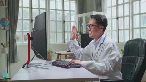 Asian Male Doctor Communicates With Patient By Video Link, Doctor Consults Patient