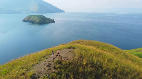 Aerial slow motion: couple tourists hiking on Lake Toba Sumatra Indonesia
