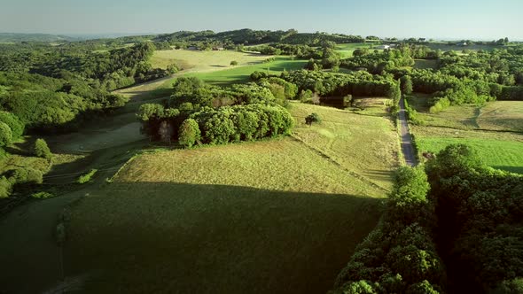 Aerial view of rolling hills and straw bales in field in Correze, France.