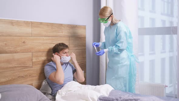 Young Man at Home Taking a Test for COVID19 By Female Doctor