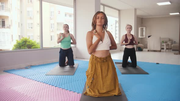 Three Women Having Yoga Classes in the Bright Studio the Younger One Stands in the Front and All of