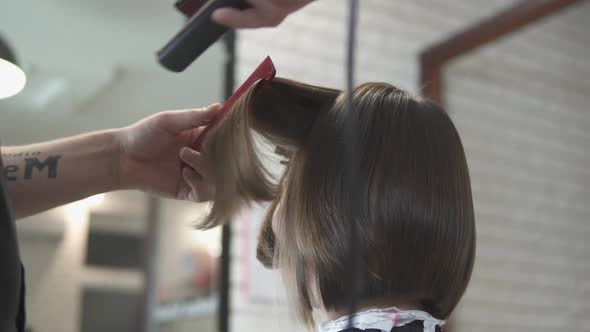 Closeup Shot of a Woman Having Her Hair Straightened in Hair Salon