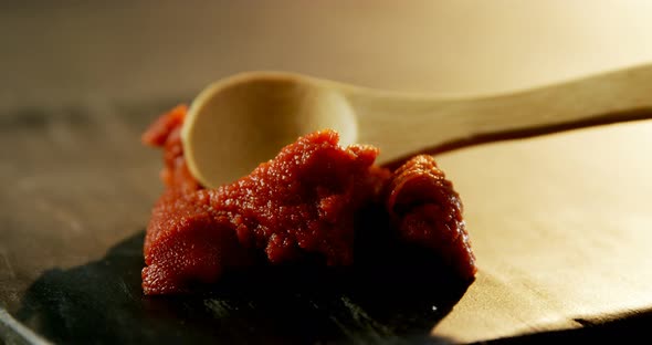 Red chili chutney being spread on concrete board 4k