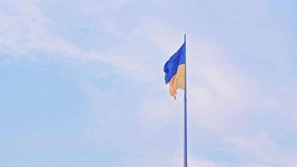 the Flag of Ukraine a Silk Flag Waving Against the Background of the Setting Blue Sky on a Large