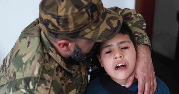 Happy veteran soldier man hugging his son in wheelchair after returning from military service