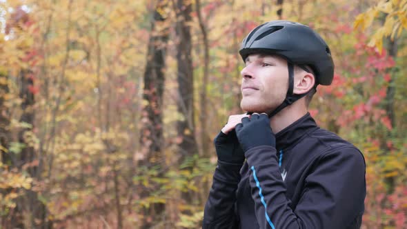 Man cyclist preparing for training ride on bicycle wearing helmet, sunglasses and gloves