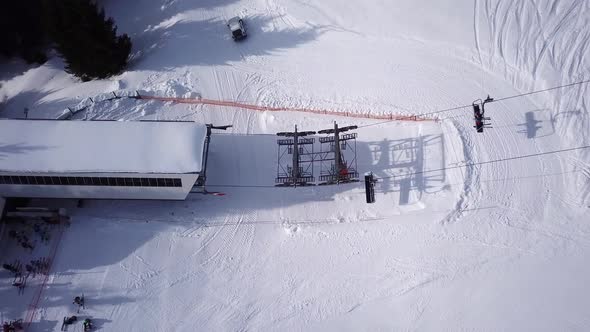 Aerial Top view of Ski chair Lift. Few people for Transportation in Ski Resort. Skiers and Snowboard