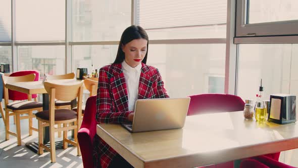 Woman Freelancer Is Working On Laptop In Cafe