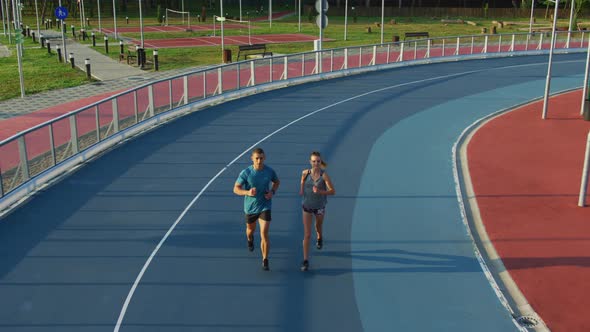 Young couple running on a track