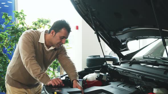 A Professional Man Opened the Hood and Studied the Details of the Car