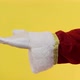 Close-up of Santa Claus gloved hand show giving gesturing on yellow background. - VideoHive Item for Sale