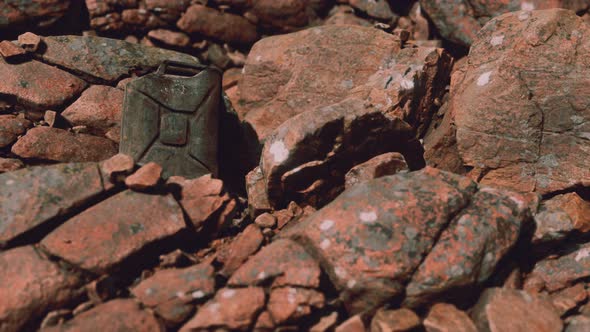 Old Rusty Metal Canister for Gasoline Fuel at Rocks