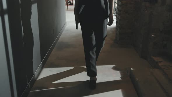 Unrecognizable Business Lady Walking through Dark Office Corridor